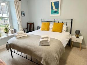 a bedroom with a bed with towels on it at The Old Bakehouse in Colyton