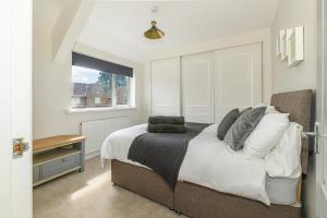 a bedroom with a large bed and a window at Stylish 3 Bed House Near Hospital, Racecourse, Free Parking 