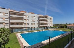 a large swimming pool in front of a building at Laguna 3 Rooms Piscina in Chipiona +12 photos