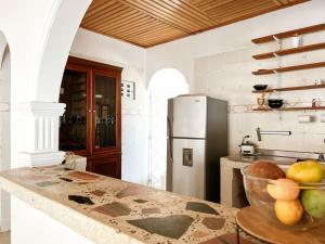 uma cozinha com um frigorífico e uma tigela de fruta no balcão em Hermosa habitación en casa campestre con piscina cerca al aeropuerto em Santa Marta