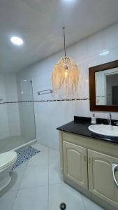 y baño con lavabo, aseo y espejo. en Hermosa habitación en casa campestre con piscina cerca al aeropuerto en Santa Marta