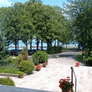 a park with flowers and trees and a sidewalk at BLKI Vendégház in Tihany