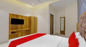 a bedroom with a bed with a tv on the wall at Hotel Planet Villa in Ahmedabad