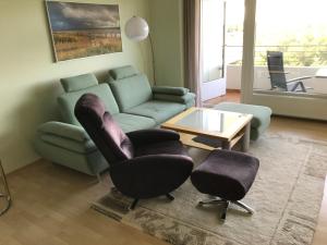 a living room with a couch and two chairs and a table at Sunnyside 95 in Timmendorfer Strand