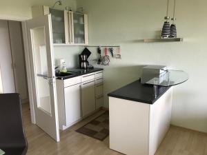 a kitchen with white cabinets and a glass counter top at Sunnyside 95 in Timmendorfer Strand