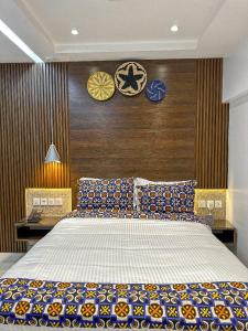 a bedroom with a bed and two clocks on the wall at Klik Klak Appart Hotel in Cotonou