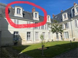 a building with a red sign in front of a tree at TOURS quartier halles 70m2 in Tours