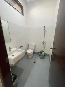 La salle de bains est pourvue de toilettes et d'un lavabo. dans l'établissement Shaka House at alun alun kidul, à Timuran