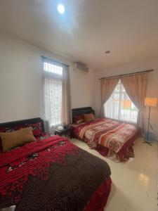 - une chambre avec 2 lits et une fenêtre dans l'établissement Shaka House at alun alun kidul, à Timuran