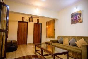 a living room with a couch and a coffee table at Classic Villa 3 BHK Villa with pool in chondhi, Kihim, Alibag in Alibag