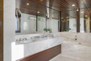 a bathroom with two sinks and a large mirror at Pestana Bahia Praia Nature & Beach Resort in Vila Franca do Campo
