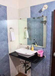a bathroom with a sink and a mirror at Classic Villa 3 BHK Villa with pool in chondhi, Kihim, Alibag in Alibag