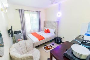 Dormitorio pequeño con cama, escritorio y silla en Greer Homes Sun Sweet, en Shanzu