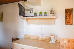 a room with a desk with a tv on a wall at Hilja's Oliven Garden Bungalows in Ulcinj