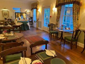 um restaurante com mesas e cadeiras num quarto em The Casterbridge em Dorchester