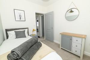 um quarto com uma cama, uma secretária e um espelho em Stylish 3 Bed House Near Hospital, Racecourse, Free Parking 