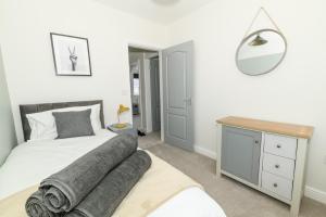 a bedroom with a bed and a desk and a mirror at Stylish 3 Bed House Near Hospital, Racecourse, Free Parking 
