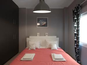 um quarto com uma cama grande com duas toalhas em The Acropolis Apartment em Atenas