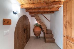 a hallway with a wooden staircase with a vase next to a door at Rodos Old Town Aqua Luxury Suites in Rhodes Town