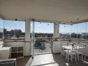 a living room with a table and chairs and windows at Apartamento playa y golf I Retamar in Retamar