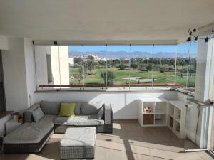 a living room with a couch and a large window at Apartamento playa y golf I Retamar in Retamar