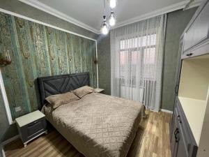a bedroom with a bed and a large window at Villa in Guba in Alekseyevka