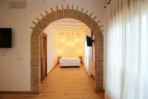 an archway leading to a bedroom with a bed at Villa Xarahiz in Jaraiz de la Vera
