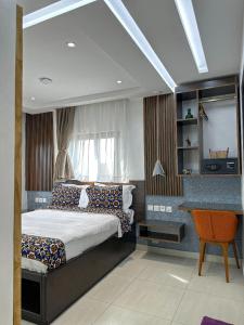 a bedroom with a bed and a chair in it at Klik Klak Appart Hotel in Cotonou