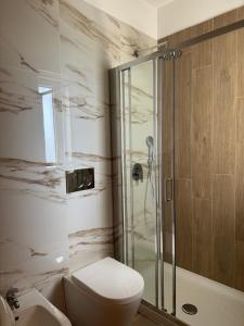 a bathroom with a toilet and a glass shower at Hotel Airone in Alberobello