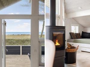 オテルプにある6 person holiday home in Otterupの海の景色を望むリビングルーム(暖炉付)
