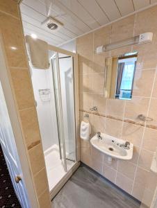 ein Bad mit einer Dusche und einem Waschbecken in der Unterkunft The George Guest House in Plymouth