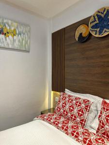 a bedroom with a bed with a red and white blanket at Klik Klak Appart Hotel in Cotonou