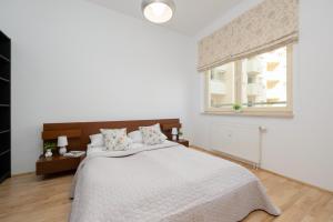 a white bedroom with a large bed and a window at Bukowińska Apartments with Balcony and Parking and Swimming Pool by Renters in Warsaw
