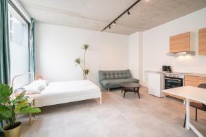 Una sala de estar con una cama y una cocina. en Opera Square Apartments in Antwerp Centre, en Amberes