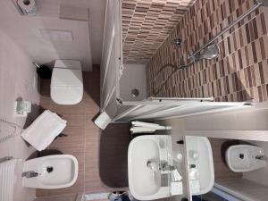 a bathroom with two toilets and two sinks and a mirror at Affittacamere Il Veliero in Levanto