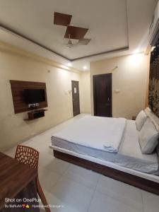 a bedroom with a bed and a flat screen tv at WAY INN FAMILIAR in Hyderabad