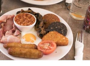 a plate of breakfast food with eggs sausage and beans at Leabrook House in Castlemaine