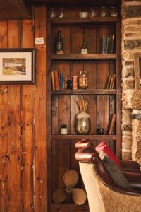um quarto com uma cadeira e uma prateleira de livros em Port William Inn em Tintagel