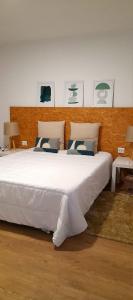 1 dormitorio con 1 cama blanca grande con almohadas en Upstairs Home, en Ponta Delgada