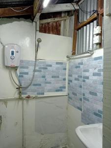 ein Bad mit einer Dusche und einem Waschbecken in der Unterkunft BUDJET HOMESTAY CAMERON HIGHLANDS in Tanah Rata