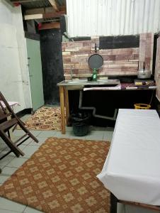 eine Küche mit einem Tisch und einem Waschbecken in einem Zimmer in der Unterkunft BUDJET HOMESTAY CAMERON HIGHLANDS in Tanah Rata