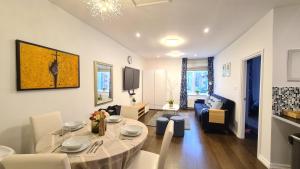 a living room with a table and a living room with a couch at Delightful 2 Bedroom Apartment! in London