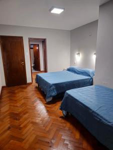 twee bedden in een kamer met houten vloeren bij Punta Blanca in Salta