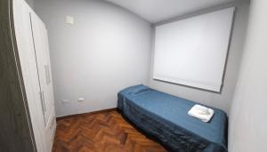 een kleine slaapkamer met een blauw bed en een raam bij Punta Blanca in Salta