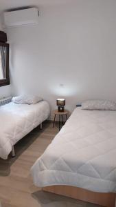 a bedroom with two beds and a side table at Casa Gabritana in Sotillo de las Palomas