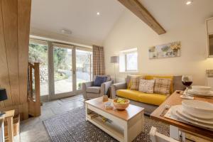 a living room with a yellow couch and a table at Little Croft in Kettlewell