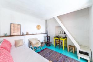 フォルカルキエにあるLa maison de Fridaのベッド、デスク、階段が備わる客室です。