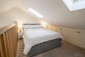 a bedroom with a large bed with white sheets at Little Croft in Kettlewell