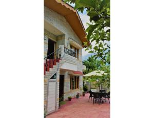 an external view of a house with a patio at Acharya Cottage, Manali in Manāli