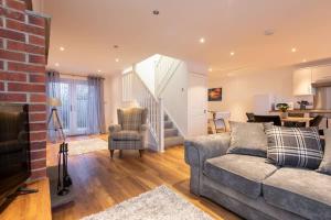 Beautiful Cottage in Durham with Pool Table في دورهام: غرفة معيشة مع أريكة وجدار من الطوب